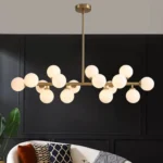 Contemporary gold linear island lighting fixture with 16 milk white glass globes for modern homes.