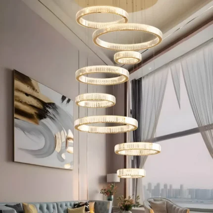 Oversized 8-ring Gold Crystal Chandelier installed in a luxury living room with floor-to-ceiling windows.