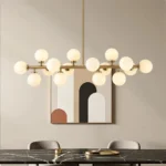 Minimalist 16-globe linear gold pendant light in a contemporary dining room with abstract wall art.