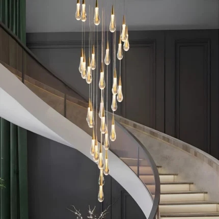 Long LED teardrop pendant light fixture illuminating a grand contemporary winding stairwell