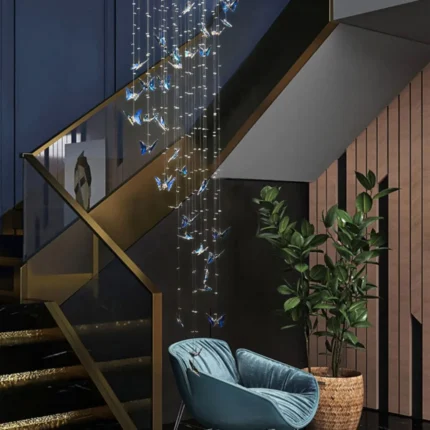 Extra long spiral butterfly pendant light hanging over a contemporary glass staircase.