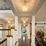 Multiple mini gold crystal chandeliers used as luxury foyer lighting along a grand hallway.