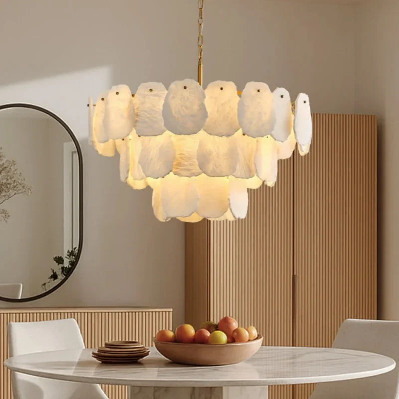 Modern alabaster chandelier with gold frame over round marble dining table in luxury home