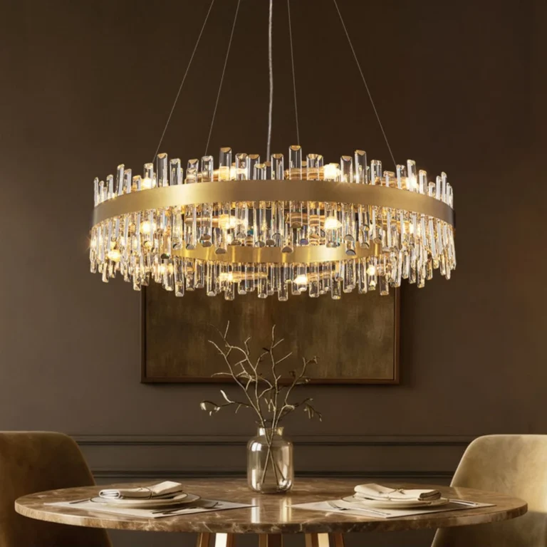 Modern antique brass crystal chandelier installed over a round marble dining table.