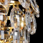 Extreme macro shot showing the hand-cut textured crystal scales of the gold chandelier.