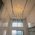Artistic beaded chandelier for 2 story foyer providing elegant grand entrance lighting