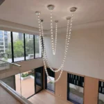 Lux beaded chandelier with modern crystal necklace design for high ceiling stairwell