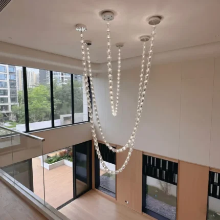 Lux beaded chandelier with modern crystal necklace design for high ceiling stairwell