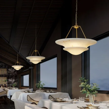 3 cascading luxury modern alabaster pendant lights hung in a row over a long kitchen island or dining table dining room lighting