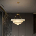 close up shot of white marble pendant light texture showing translucent faux alabaster shade and brushed brass finish hardware details