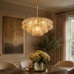 Amber glass chandelier with gold finish above dining room table