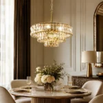 Tiered glass chandelier with gold finish above round dining table