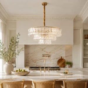 Glass chandelier with tiered gold finish above white kitchen island