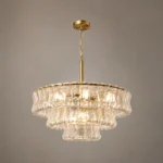 Close up lighting view of tiered glass chandelier with gold finish