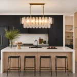 Modern linear chandelier with hand-blown glass and gold frame above a kitchen island