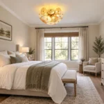 Glass disc chandelier with gold-tone frame installed in a bright neutral bedroom