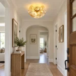 Glass disc chandelier with textured glass discs installed in a modern hallway