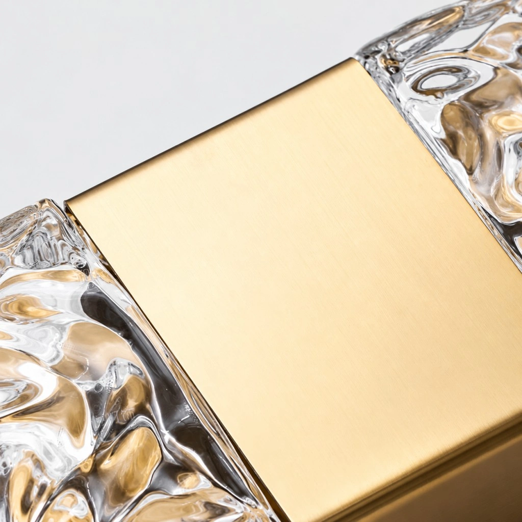 Close-up of the brushed gold metal finish and textured crystal shades on a wall sconce