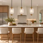 Three clear glass pendant lights for a kitchen island, featuring ribbed glass shades and antique bronze accents.