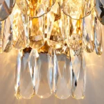 Close-up of faceted clear crystal pendants and cascading tiers on a luxury wall sconce.