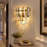 Luxury crystal wall sconce with smoke gray and clear crystals above an entryway console table.