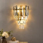 Crystal sconces with smoke gray and clear tiered crystals, warm LED lighting and gold-tone metal frame.