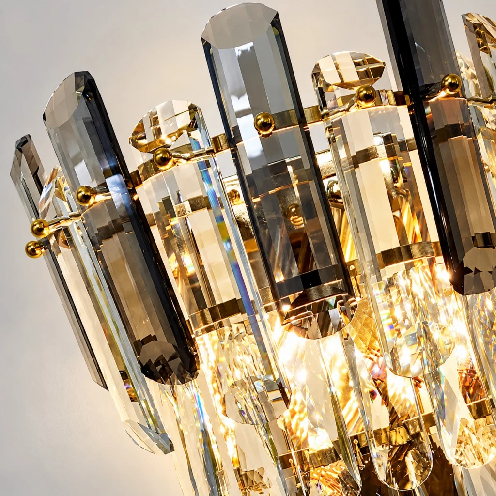 Close-up of smoke gray and clear faceted crystal bars with gold-tone metal fittings.