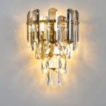 Front view of an illuminated smoke gray and clear crystal wall sconce with cascading crystal tiers.
