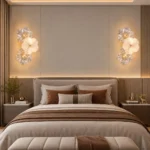 Two compact three-flower glass wall lights above bedside tables in a warm modern bedroom
