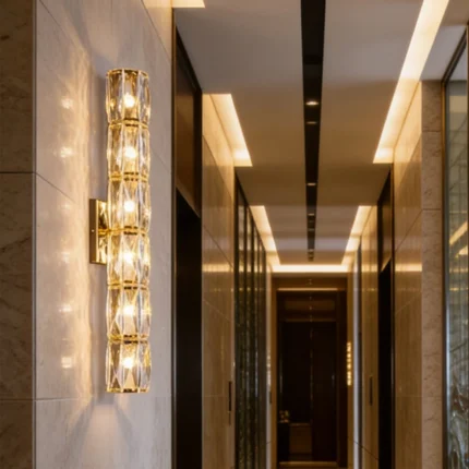 Gold crystal wall sconce with six illuminated sections in a modern hallway with stone walls