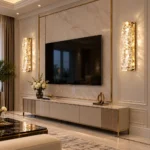 Two gold K9 crystal wall sconces installed on either side of a living room TV wall