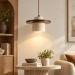 Single wabi sabi pendant light illuminating a living room with a round stone coffee table and neutral furnishings.