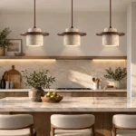 Three wabi sabi pendant lights hanging above a marble kitchen island in a warm modern kitchen.